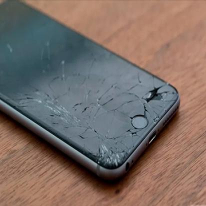 Cracked black iphone on wooden surface